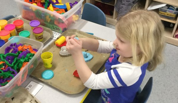 Young girl playing with playdoh.